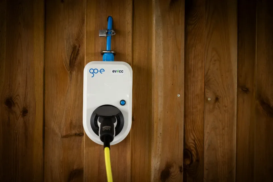 go-e charger on a wooden wall with evcc sticker