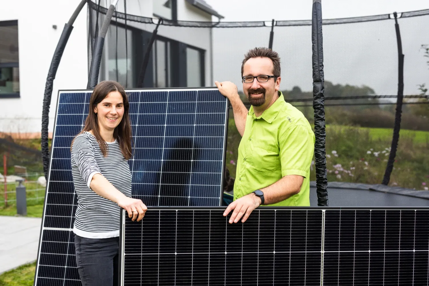 Ulrike and Gunther with PV modules by a trampoline